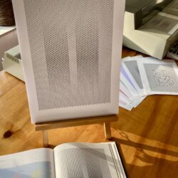 A book with an image of Arthur Hoener's Duo, together with a pen plotted recreation and a pen plotter in the background.